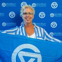 An alumna posing with the GV flag